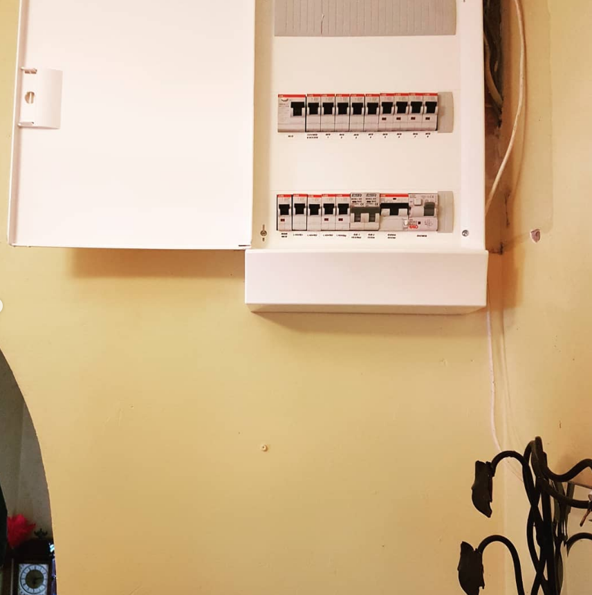 A fitted consumer unit with its breakers, on a wall